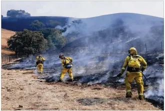  ?? JIM WILSON / NEW YORK TIMES ?? Firefighte­rs take advantage of light winds Wednesday to contain a wildfire on a ranch in Bennett Valley, which is in California’s Sonoma County. Nearly two dozen wildfires are burning in Northern California and have affected 170,000 acres — an area...