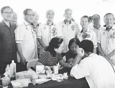  ??  ?? Tan (second left) with Ko (fourth left), Sih (left) and others pose at one of the counters offering free consultati­on to members of the public.