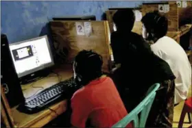  ?? TATAN SYUFLANA — THE ASSOCIATED PRESS ?? HOLD FOR RELEASE ON WEDNESDAY AT 12:01 A.M. EDT; THIS STORY MAY NOT BE PUBLISHED, BROADCAST OR POSTED ONLINE BEFORE WEDNESDAY AT 12:01 A.M. EDT - FILE - In this Monday file photo, youths look at computer screens at an Internet cafe in Jakarta,...