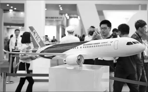  ?? FAN SONG / FOR CHINA DAILY ?? A visitor takes photos of a model of the C919 plane, China’s first home-developed large passenger jet, at an exhibition in Beijing.