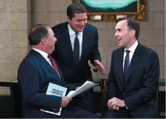  ?? CP PHOTO ?? Minister of Finance Bill Morneau, right, chats with Conservati­ve Leader Andrew Scheer, centre, in between TV interviews after tabling the budget in the House of Commons on Parliament Hill in Ottawa on Tuesday.