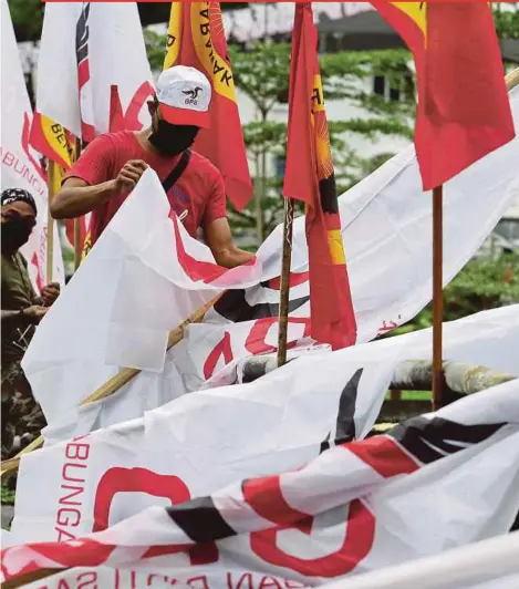  ?? PIC BY AIZUDDIN SAAD ?? Volunteers putting up Gabungan Parti Sarawak flags in Kuching yesterday.