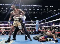  ??  ?? CICLÓN. El árbitro separa a Wilder mientras Stiverne cae a la lona.