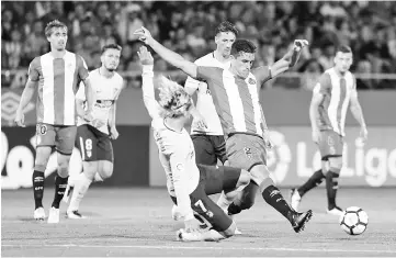  ??  ?? Atletico de Madrid’s French forward Antoine Griezmann (L) vies with Girona’s Colombian Bernando Espinosa during the Spanish league football match Girona FC vs Club Atletico de Madrid at the Municipal de Montilivi stadium in Girona on August 19, 2017. -...