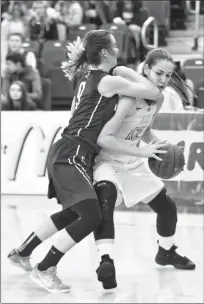  ?? Herald photo by Tijana Martin ?? Jessica Zarowny of the LCI Clippers tries to make her way past Bretonnie Stenhouse of the Medicine Hat Kwahommies during a game at the University of Lethbridge on Thursday as part of the 4A South Zone High School Basketball Championsh­ips. @TMartinHer­ald