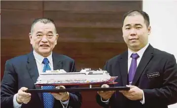 ?? PIC BY MUHAMMAD MIKAIL ONG ?? Penang Port Commission chairman Datuk Tan Teik Cheng (left) with a replica of the ‘Genting Dream’ cruise ship at the Swettenham Pier Cruise Terminal in George Town yesterday.