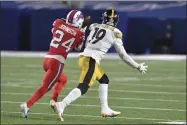  ?? ADRIAN KRAUS - THE ASSOCIATED PRESS ?? Buffalo Bills cornerback Taron Johnson ( 24) intercepts a pass intended for Pittsburgh Steelers wide receiver Juju Smith- Schuster ( 19) and returns it for a 51- yard touchdown during the first half of an NFL football game in Orchard Park, N. Y., Sunday, Dec. 13, 2020.