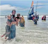  ?? —AP ?? A Rohingya Muslim man walks to the shore carrying two children after they arrived on a boat in Shah Porir Dwip, Bangladesh from Myanmar. Violence in Myanmar saw mass exodus of Rohingyas to Bangladesh.