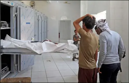  ??  ?? أقارب يمني سقط في القصف على تعز يستلمون جثته من المستشفى أمس