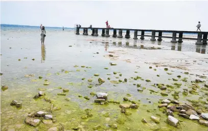  ?? Photos / AP ?? Lake Garda’s water level has dropped critically following severe drought, resulting in rocks emerging around the Sirmione Peninsula.