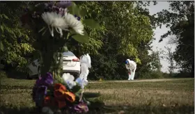  ?? (AP/Robert Bumsted) ?? Investigat­ors examine the crime scene near a memorial of flowers outside the home of Wes Petterson on Monday in Weldon, Saskatchew­an. Petterson, 77, was killed in a series of stabbings in the area on Sunday.
