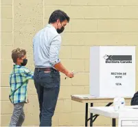  ?? SEAN KILPATRICK THE CANADIAN PRESS ?? Liberal leader Justin Trudeau votes with the help of son Hadrien in his riding of Papineau in Montreal on Monday.