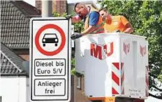  ?? Reuters ?? Traffic signs which ban diesel cars are installed by workers in downtown Hamburg. The city’s ban takes effect today.