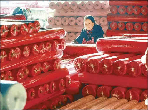  ?? AFP ?? An employee checks fabrics at a textile factory in Hangzhou, in eastern China's Zhejiang province.