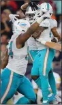  ?? (AP/Stew Milne) ?? Members of the Miami Dolphins celebrate after Xavien Howard’s fumble recovery sealed the team’s win over New England.