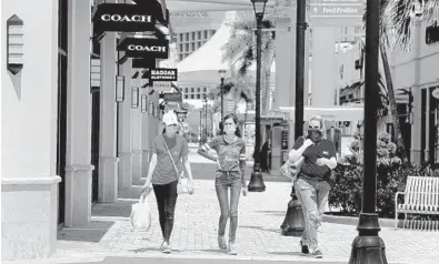  ?? CARLINE JEAN/SOUTH FLORIDA SUN SENTINEL ?? Shoppers are back at Palm Beach Outlets in West Palm Beach as Palm Beach County started Phase 1 of reopening on Monday.