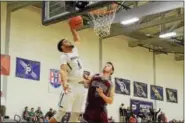  ?? SAM STEWART - DIGITAL FIRST MEDIA ?? Phoenixvil­le’s Shyheim Abernathy goes in for a dunk while Pottsgrove’s Nik Curnew defends during the first half.