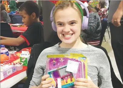  ??  ?? Kalaina Sutherland, 14, holds up her Polly Pockets which she received as a gift at the Virginia School Christmas Party on Tuesday at the Five30 Center in Marysville. BELOW: Lorenzo Sandoval, 11, poses with the Beyblade slingshot toys he received Tuesday.