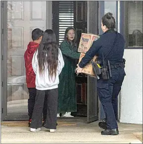  ?? ROD THORNBURG / FOR THE CALIFORNIA­N ?? Bakersfiel­d Police Officer Neida Mendoza delivers boxes of food Tuesday to 72-year-old Ardath Alvizo. “(God) bless you,” Alvizo said to Mendoza. Mendoza is accompanie­d with Alvizo’s neighbors.