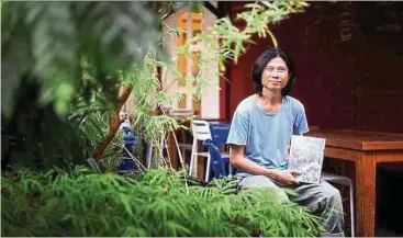  ?? — The Straits Times/ANN ?? Singaporea­n artist Chua with his first book of black-and-white photograph­s that documents the beauty of Singapore’s forests.