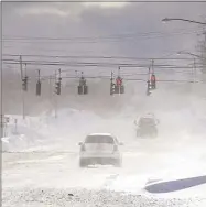  ?? ?? Cars drive through blowing, drifting snow on McKinley Parkway in Hamburg in Erie County, N.Y.