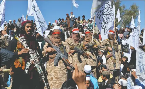  ?? NOORULLAH SHIRZADA / AFP VIA GETTY IMAGES FILES ?? Afghan Taliban militants and villagers gather in March as they celebrate the peace deal and their victory in the con
flict with the U. S. in Afghanista­n. This week marks the 19th anniversar­y of Operation Enduring Freedom.