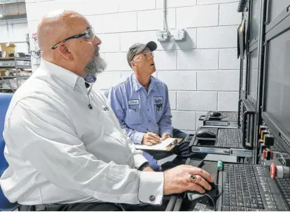  ?? Photos by Marvin Pfeiffer / San Antonio Express-News ?? Mickey Argo (left) and Doug Czaja of Southwest Research Institute monitor a test on a Samsung 37.6 amp battery Wednesday.