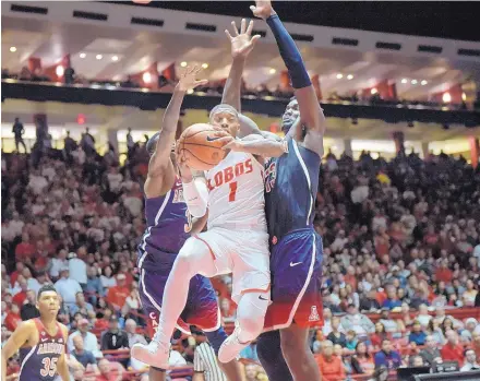  ?? ROBERTO E. ROSALES/JOURNAL ?? University of New Mexico’s Chris McNeal (1) penetrates to the basket while being chased by Arizona’s Dylan Smith, left, and Deandre Ayton. The No. 23 Wildcats shot a sizzling 64 percent from the field and had an easy 89-73 win over the host Lobos...