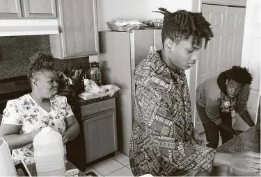  ?? Photos by Elizabeth Conley / Staff photograph­er ?? Massa Jarrett, a certified nursing assistant atWestwood, gets ready for work as her sons prepare their lunch.