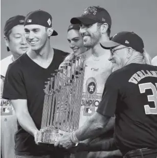  ?? Kevork Djansezian, Getty Images ?? Justin Verlander, wearing aWorld Series T- shirt while holding the championsh­ip trophy Wednesday night, will be back with Houston next year.