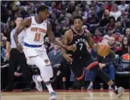  ?? NATHAN DENETTE — THE CANADIAN PRESS VIA ASSOCIATED PRESS ?? Raptors guard Kyle Lowry, left, protects the ball fromKnicks guard Frank Ntilikina during the first half of Saturday’s game in Toronto.