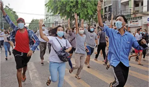  ?? | Reuters ?? ANTI-COUP protesters flash the three-finger salute during a flash mob protest in Yangon, Myanmar yesterday.