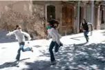  ?? -AFP photos ?? Joan, 45, chases his daughters Ines, 11, and Mar, 9, as they play in the street on Sunday, in Barcelona, during a national lockdown to prevent the spread of the COVID-19 disease.