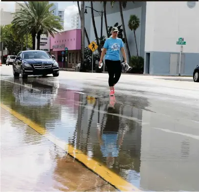  ?? PEDRO PORTAL pportal@miamiheral­d.com ?? A woman walks on 71st Street in Miami Beach in September last year, avoiding the overflow water due to a king tide. King tides are expected now through Wednesday and Nov. 13-18.