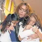  ?? ALAN DIAZ, AP ?? Nora Sandigo Otero comforts Yardley Vanegas, left, and Sherley Ramirez, right, children under her legal guardiansh­ip, as they leave the hearing.