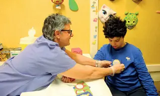  ??  ?? Un infermiera del Meyer appunta la coccarda a un bambino dopo un prelievo
