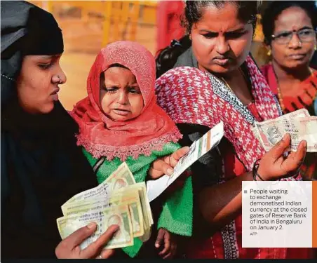  ?? AFP ?? People waiting to exchange demonetise­d Indian currency at the closed gates of Reserve Bank of India in Bengaluru on January 2.