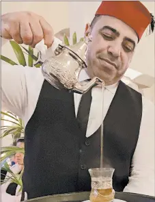  ?? FRANCOISE DROGIN/LOS ANGELES TIMES ?? A waiter pours sweet mint tea after dinner at Rick’s Cafe in Casablanca, Morocco.