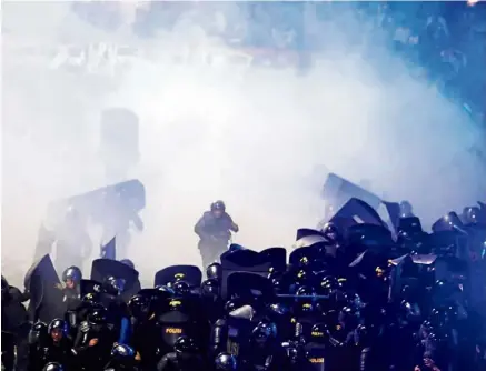  ?? — The Jakarta Post/ANN ?? Excessive force: Police firing tear gas at protesters during a riot near the Elections Supervisor­y Agency (Bawaslu) headquarte­rs in Central Jakarta.