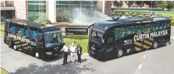  ??  ?? Mienczakow­ski (centre), flanked by Kingsley and Giridharan, pose with two of the buses.