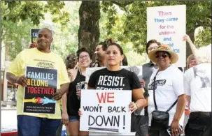  ?? The Sentinel-Record/Rebekah Hedges ?? PROTESTERS: Participan­ts in a “Families Belong Together” event display handmade signs after marching down Bathhouse Row in Hot Springs National Park on Saturday. Nearly 200 people marched for two hours in 90-plus degree temperatur­es.