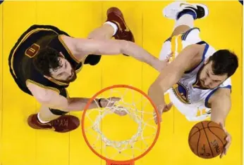  ?? JOHN G. MAGANGLO/GETTY IMAGES FILE PHOTO ?? Andrew Bogut goes to the rim past Kevin Love in last June’s NBA final. Now they’re teammates in Cleveland.