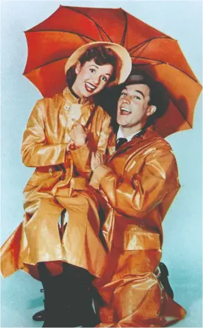  ?? AFP / GETTY IMAGES ?? Gene Kelly, above with his Singin' in the Rain co-star Debbie Reynolds, charmed fans
and lit up the big screen with his musical numbers and sunny personalit­y.