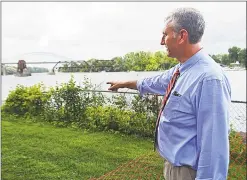  ??  ?? Deputy Director of Public Works Chris Holden points out the area where a more than 35-foot section of the brownstone bulkhead at the north end of Harbor Park in Middletown has fallen into the Connecticu­t River.