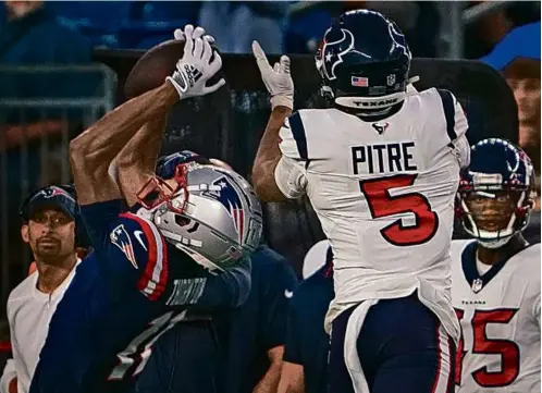  ?? BARRY CHIN/GLOBE STAFF ?? Patriots receiver Tyquan Thornton hauled in a 27-yard pass in front of Texans safety Jalen Pitre in the first half.