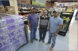  ?? TED S. WARREN — THE ASSOCIATED PRESS ?? Singh Maan, center, with his sons CJ Maan, left, and Ricky Maan, right, Monday in the grocery store they own in Chester, Mont., near the scene where an Amtrak train derailed Saturday, killing three people. When the crash happened, the family rushed to the scene with first-aid and food supplies taken right from the shelves of their store.