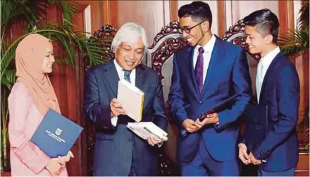  ?? PIC BY FARIZ ISWADI ISMAIL ?? Bank Negara Malaysia governor Datuk Seri Muhammad Ibrahim (second from left) with recipients of the Kijang Emas scholarshi­p in Kuala Lumpur yesterday.