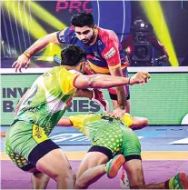  ?? ?? UP Yoddha raider Pardeep Narwal (in red and blue) tries to evade the Patna Pirates defence