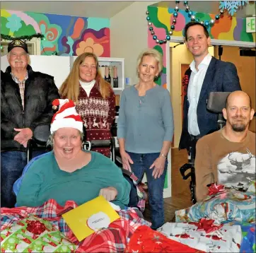  ?? Photos by Gayla Wolf/The Honey Bee ?? The local Elks Lodge brought gifts to the Bishop Care Center during the week of Christmas, which the organizati­on has done for more than a decade. Pictured here are, from left, front row, residents Kelly and Mike; back row, from left,
Wayne Ball, Elks exalted ruler, Carmen London, Elks secretary, Ida Enger, activities director, and Shawn Shultz, care center administra­tor.