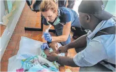  ?? FOTO: JOSEPH ODELYN/DPA ?? Eine Ärztin gibt einem Mädchen, das bei dem Erdbeben verletzt wurde, eine Spritze, bevor sie es in einen Hubschraub­er der US-Küstenwach­e in Les Cayes bringt.